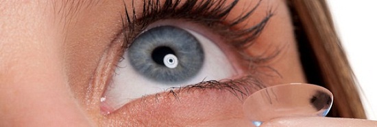 Close-up of blue woman eye with contact lens applying